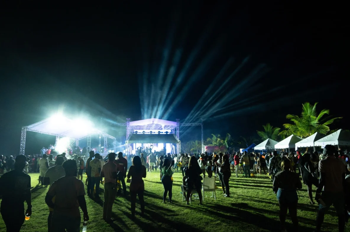 Main stage of the Caribbean Lake Park festival at night with spotlights and crowd of visitors