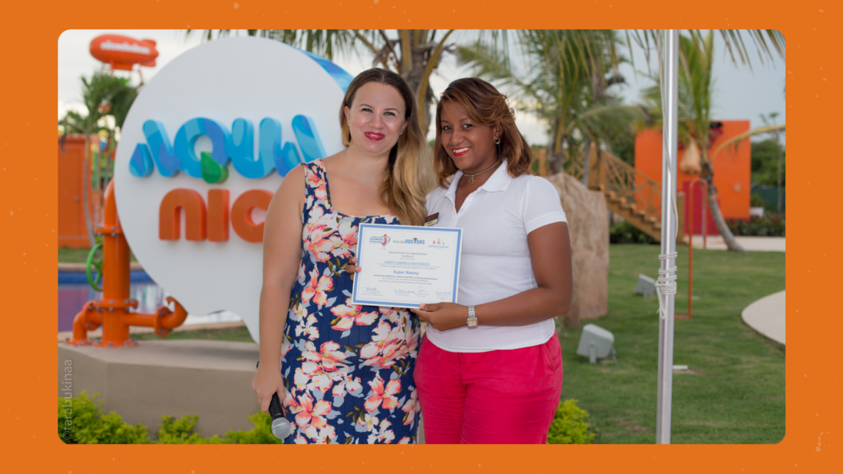 Kseniia Petrina presenting a certificate to a nanny course graduate at Aqua Nick, Nickelodeon Hotels Punta Cana